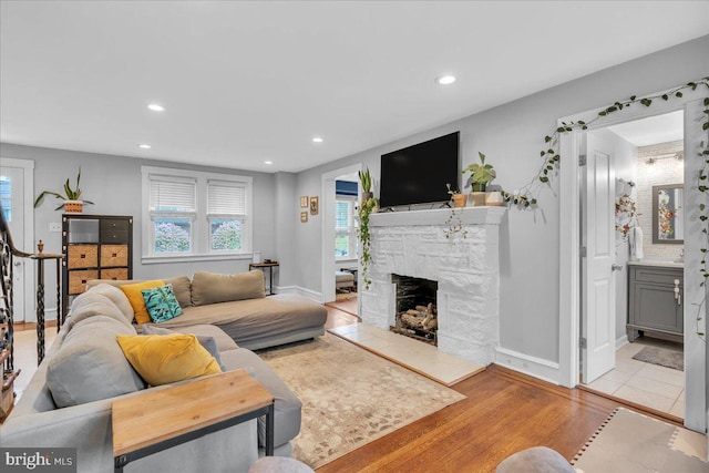 628 Mason Ave, Drexel Hill, PA 19026 - living room featuring healthy amount of natural light, a stone fireplace, recessed lighting, wood finished floors, and baseboards