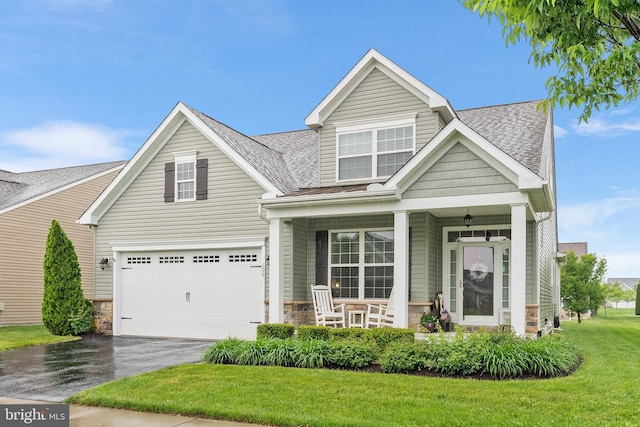 606 Garden Gate Dr, Middletown, DE 19709 - view of front facade featuring covered porch, asphalt driveway, stone siding, a front yard, and a garage