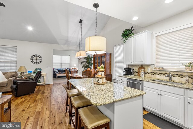 606 Garden Gate Dr, Middletown, DE 19709 - kitchen featuring a sink, stainless steel dishwasher, white cabinetry, lofted ceiling, and a center island