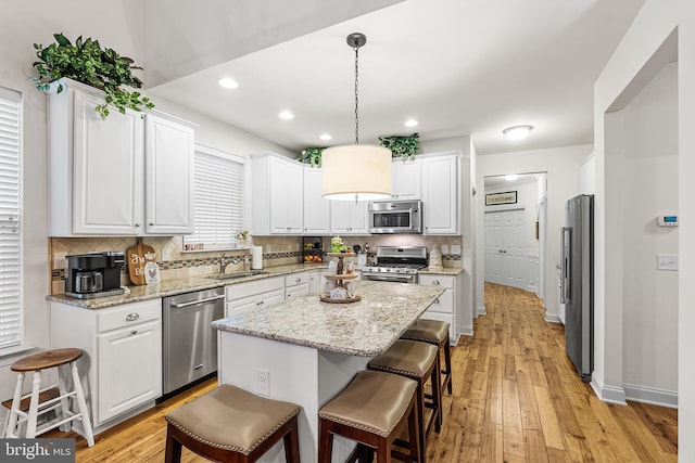 606 Garden Gate Dr, Middletown, DE 19709 - kitchen with stainless steel appliances, white cabinetry, tasteful backsplash, a kitchen breakfast bar, and recessed lighting