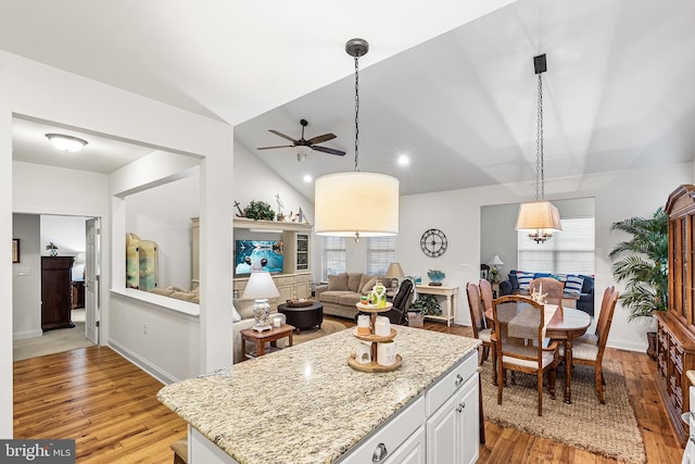 606 Garden Gate Dr, Middletown, DE 19709 - kitchen featuring light wood-style flooring, ceiling fan, light stone countertops, lofted ceiling, and a kitchen island