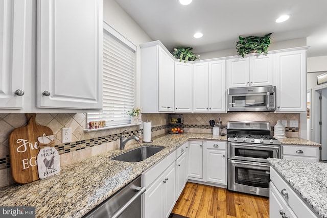 606 Garden Gate Dr, Middletown, DE 19709 - kitchen with stainless steel appliances, a sink, white cabinetry, tasteful backsplash, and recessed lighting