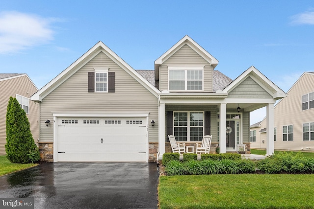 606 Garden Gate Dr, Middletown, DE 19709 - view of front of house featuring covered porch, stone siding, driveway, and a garage