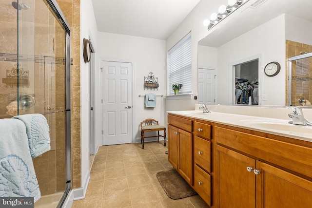 606 Garden Gate Dr, Middletown, DE 19709 - full bathroom featuring a shower stall, tile patterned floors, double vanity, and a walk in closet