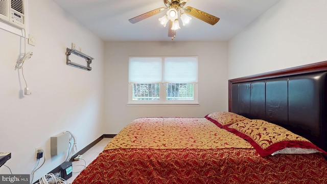 tiled bedroom featuring ceiling fan and baseboards
