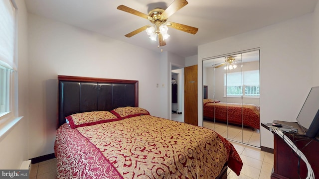 bedroom with a closet, light tile patterned flooring, and ceiling fan