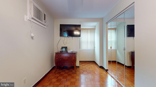 corridor with baseboards and a wall mounted air conditioner