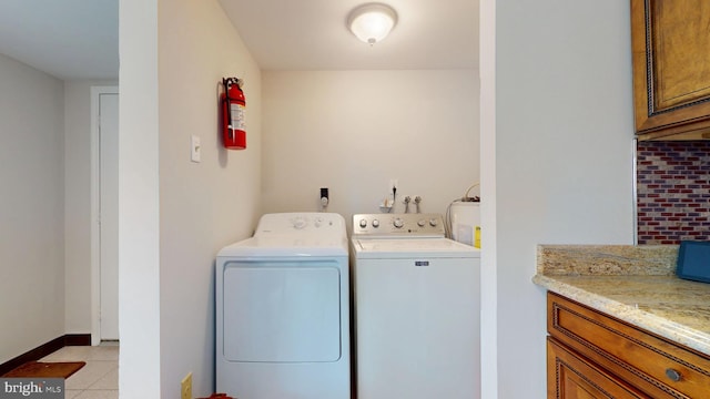 laundry area with laundry area, washer and clothes dryer, baseboards, and light tile patterned floors