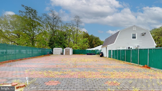 view of patio featuring an outbuilding, fence, and a shed