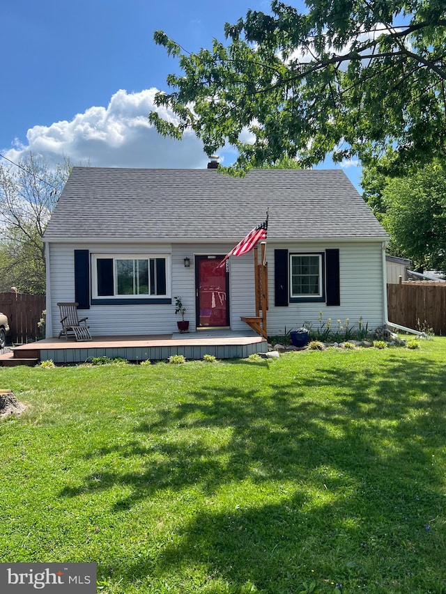 single story home with fence, a shingled roof, a front lawn, and a deck