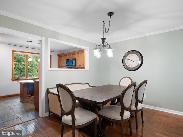 dining room with baseboards, dark wood finished floors, crown molding, and a chandelier