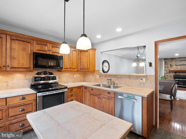 kitchen featuring stainless steel appliances, a sink, light countertops, and recessed lighting