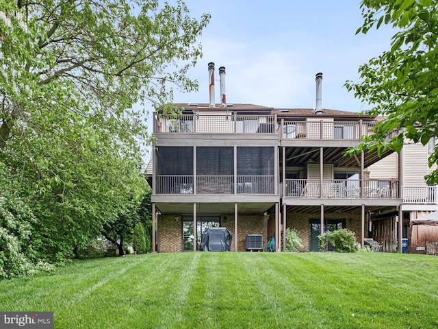 rear view of property featuring a yard, cooling unit, brick siding, and a wooden deck