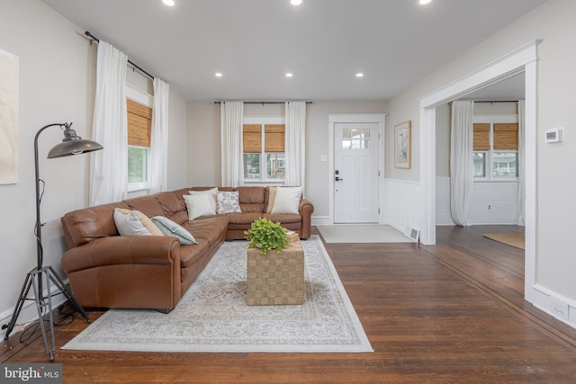 living area with wood-type flooring, recessed lighting, and a wainscoted wall