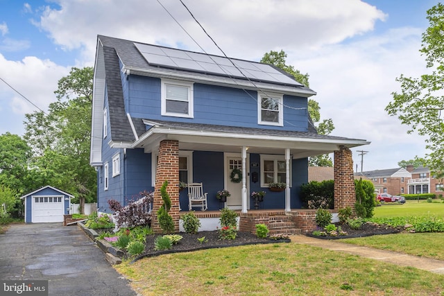 view of front of home featuring covered porch, an outdoor structure, a detached garage, solar panels, and roof with shingles