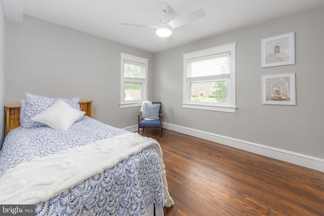 bedroom featuring baseboards, wood finished floors, and a ceiling fan
