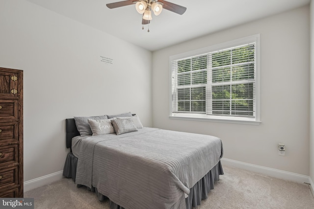 carpeted bedroom with baseboards and a ceiling fan