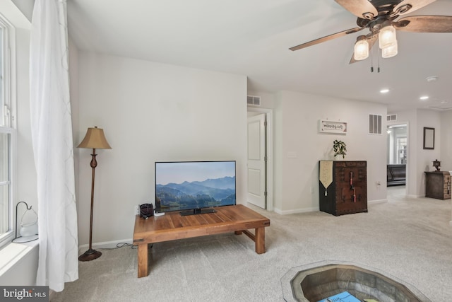 living area featuring ceiling fan, carpet floors, baseboards, and visible vents