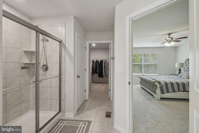 bathroom featuring a ceiling fan, ensuite bath, a shower stall, tile patterned floors, and a spacious closet
