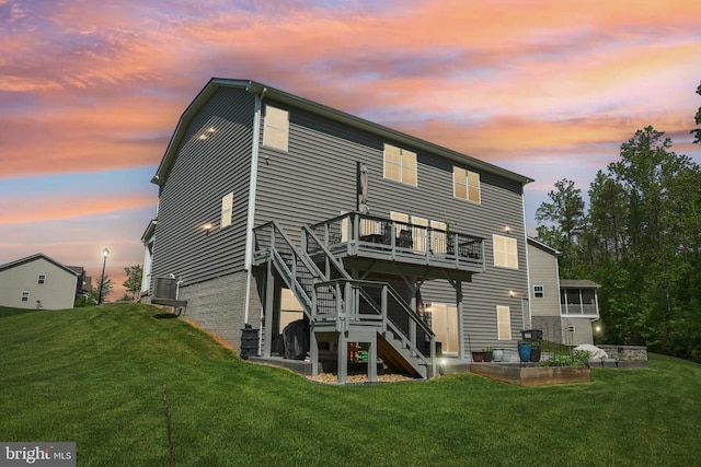 rear view of property featuring a yard, stairs, and a wooden deck