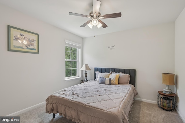carpeted bedroom with ceiling fan and baseboards