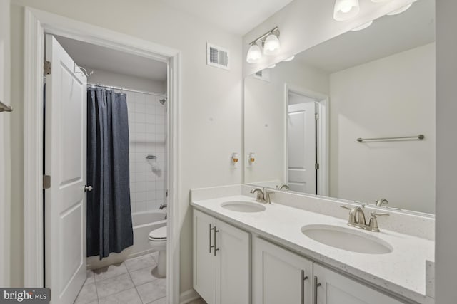 full bathroom with tile patterned floors, double vanity, visible vents, and a sink