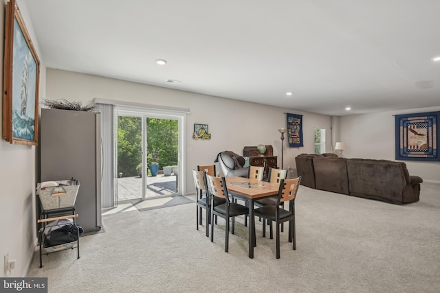 carpeted dining room with recessed lighting