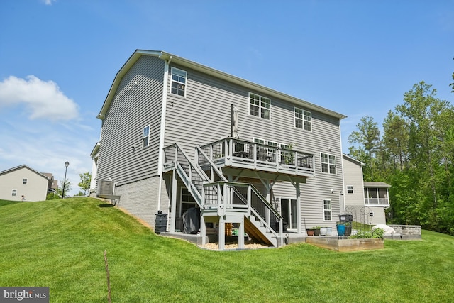 rear view of property featuring stairway, a deck, and a lawn