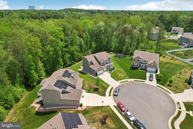 drone / aerial view with a wooded view and a residential view