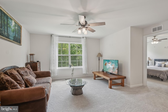 living room with visible vents, baseboards, ceiling fan, and carpet floors