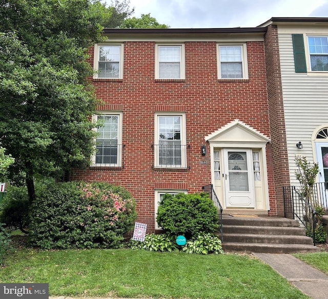 view of front of home featuring a front yard and brick siding