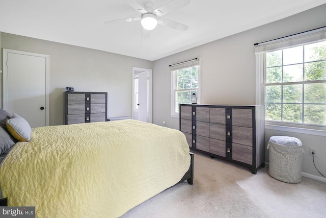 bedroom featuring light carpet, baseboards, and ceiling fan