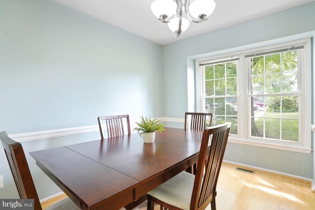 dining area featuring a chandelier, baseboards, and light wood-style flooring