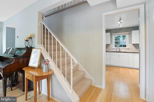 stairs featuring wood finished floors and baseboards