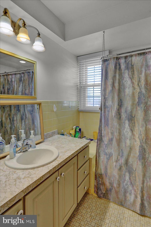 bathroom with vanity, tile walls, and a shower with curtain