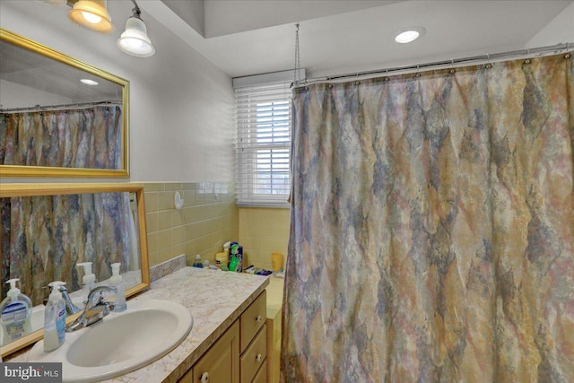 bathroom with tile walls, vanity, and a shower with curtain