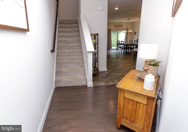 stairway featuring baseboards, wood finished floors, recessed lighting, and a chandelier