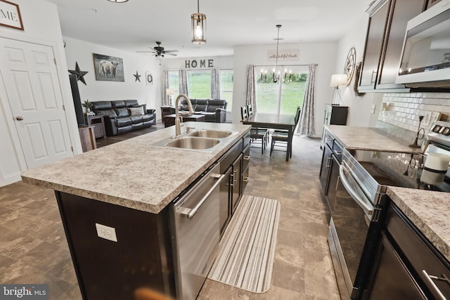 kitchen with stainless steel appliances, a sink, dark brown cabinetry, decorative backsplash, and open floor plan