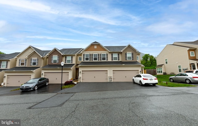 townhome / multi-family property featuring an attached garage, driveway, and a residential view
