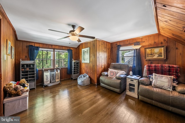 living area with wooden walls, wood finished floors, and ceiling fan