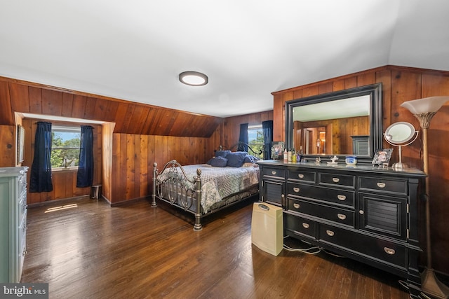 bedroom with multiple windows, wooden walls, dark wood-type flooring, and lofted ceiling