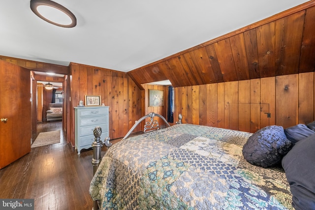 bedroom featuring wood walls, dark wood-type flooring, and vaulted ceiling