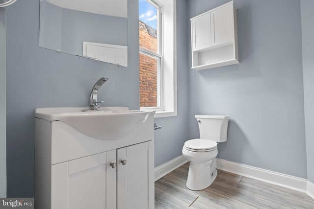 524 N Loudon Ave, Baltimore, MD 21229 - half bathroom featuring baseboards, toilet, plenty of natural light, and wood finished floors