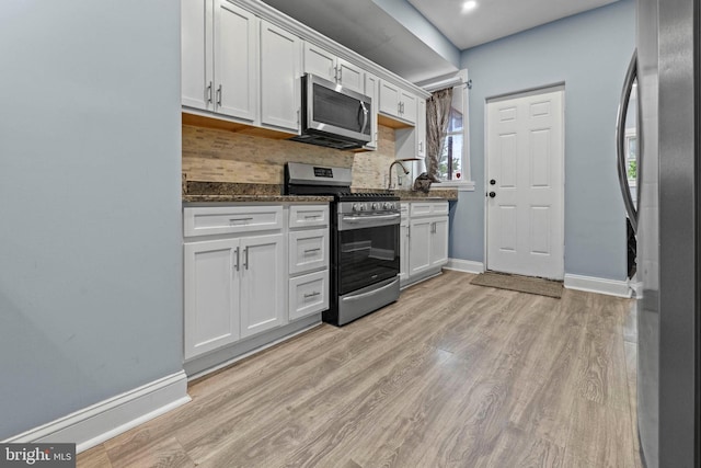 524 N Loudon Ave, Baltimore, MD 21229 - kitchen with white cabinets, decorative backsplash, baseboards, and appliances with stainless steel finishes