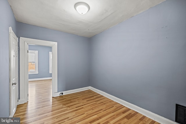 spare room featuring baseboards, light wood finished floors, and visible vents