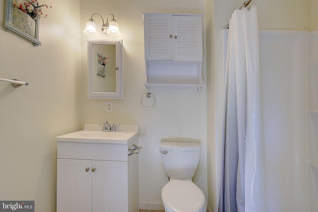 bathroom featuring toilet, vanity, and curtained shower
