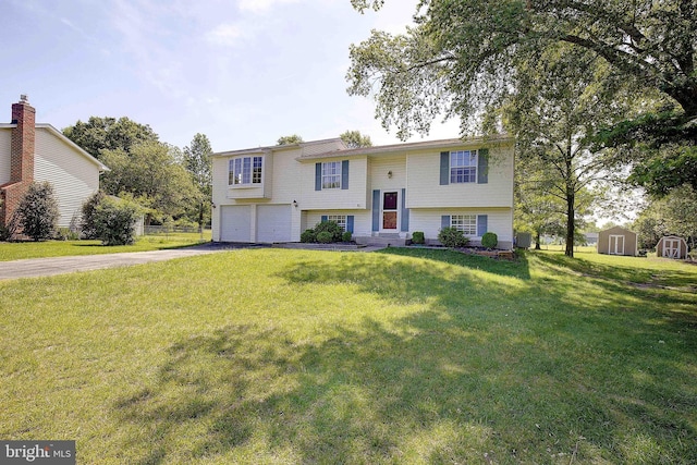bi-level home featuring driveway, a garage, a storage unit, and a front yard