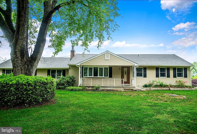 ranch-style house featuring a porch, a front yard, a chimney, and a shingled roof