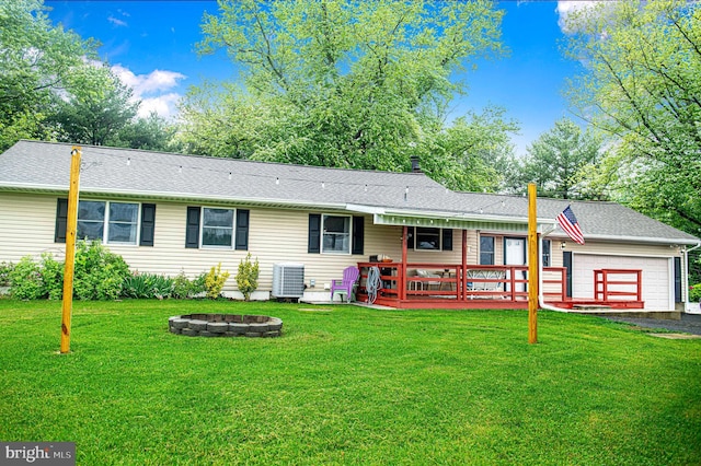 single story home featuring a fire pit, a garage, central AC unit, and a front lawn