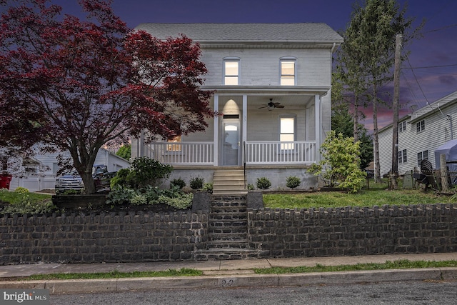 view of front of property featuring a ceiling fan, covered porch, stairway, and fence